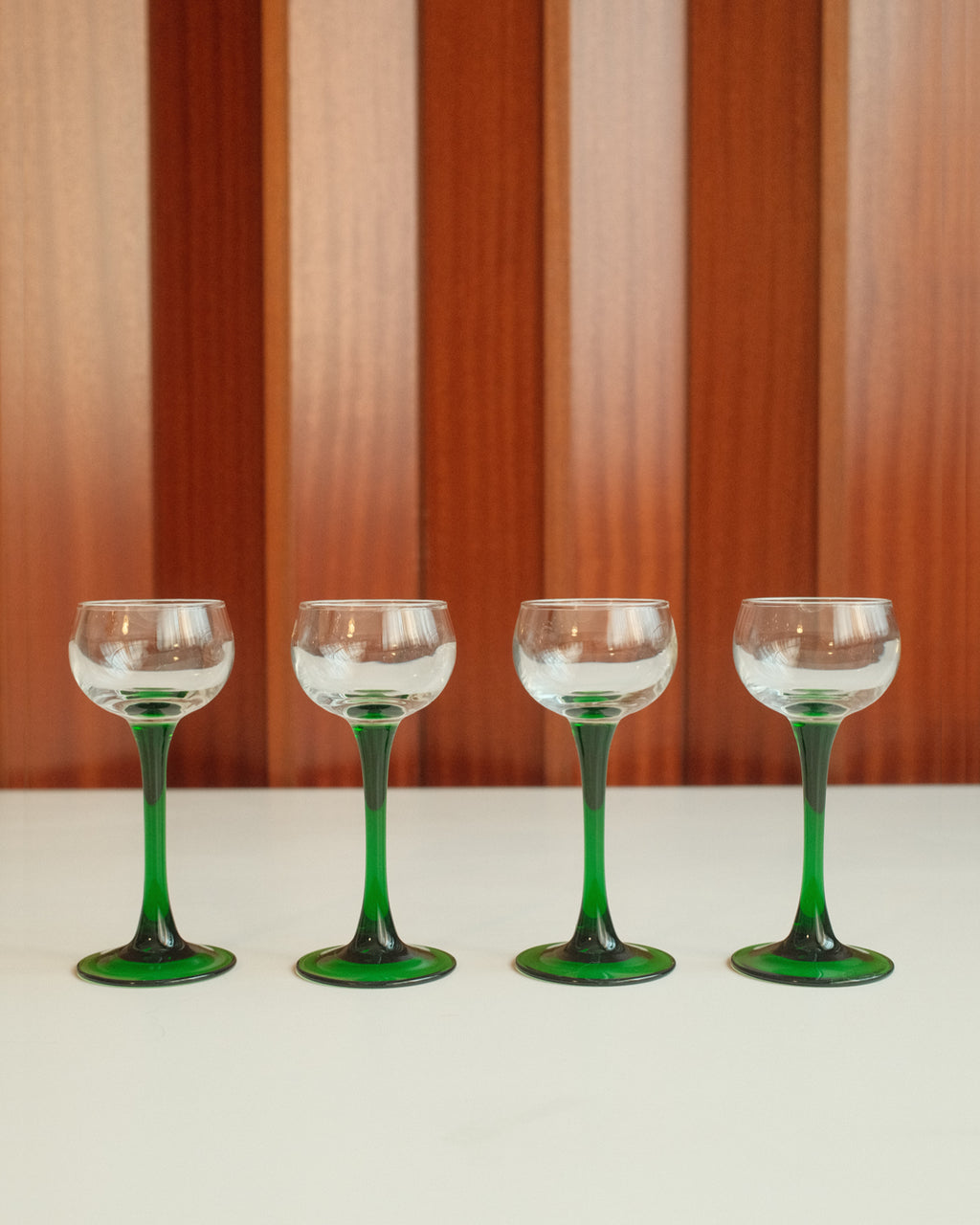 Four glasses with green stems