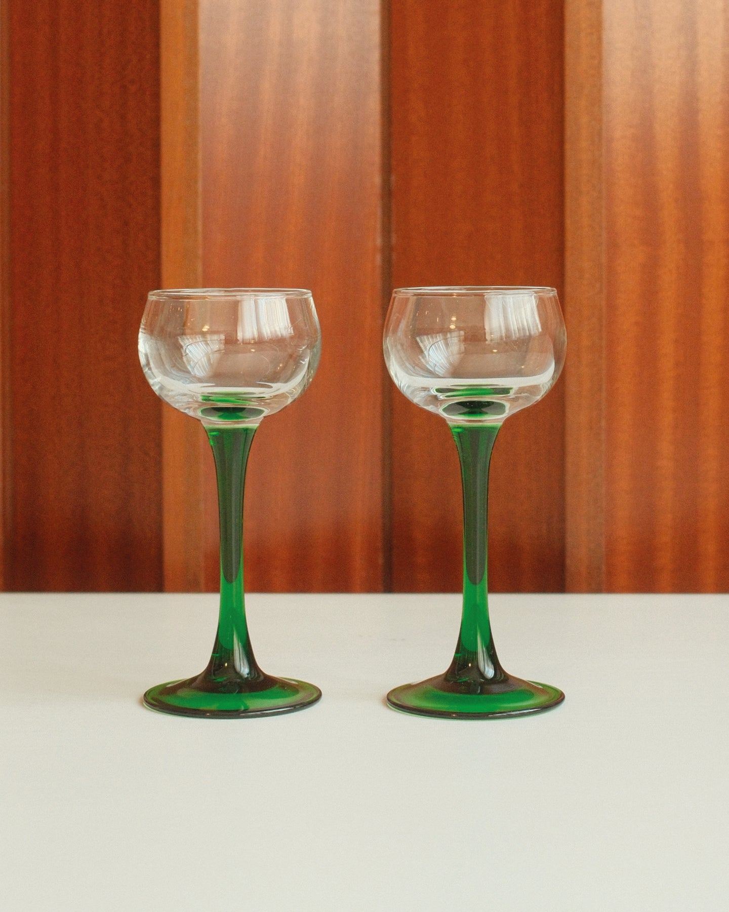 Four glasses with green stems