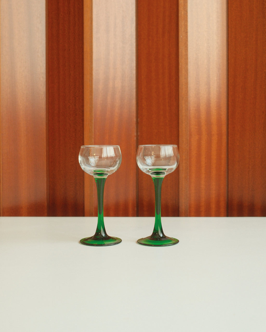 Four glasses with green stems