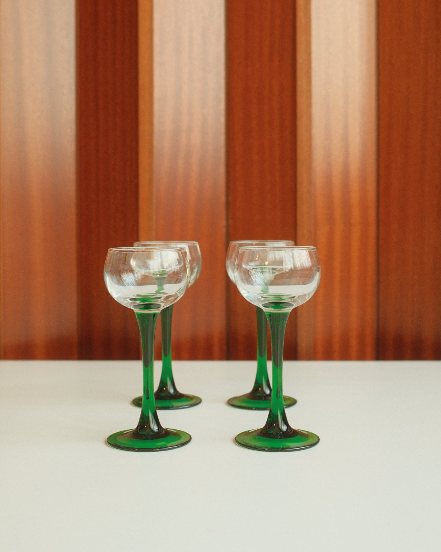 Four glasses with green stems